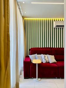 Apartamento Aquarius Residence في فورتاليزا: غرفة معيشة مع أريكة حمراء وطاولة