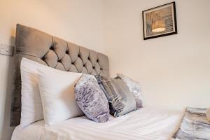 a bed with pillows on it in a bedroom at 2 Bedrooms - New Street - Sleeps 4 in Worcester +18 photos