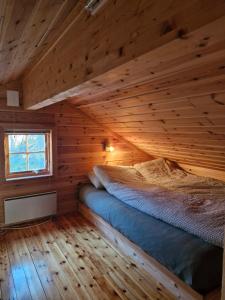 una camera da letto con un letto in una cabina di legno di Fjellvang a Haglebu
