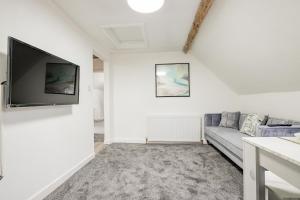 a living room with a couch and a flat screen tv at 2 Bedrooms - New Street - Sleeps 4 in Worcester
