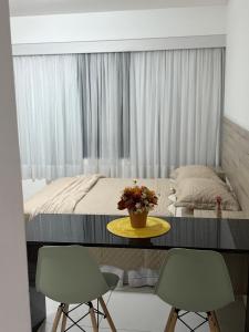 a bedroom with a bed with a table and two chairs at Golden Point Apartamento em Recife in Recife