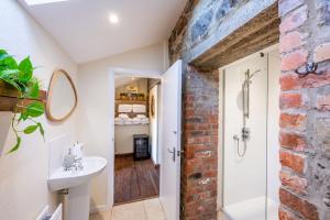 a bathroom with a white sink and a brick wall at Tullymurry House in Ardarragh