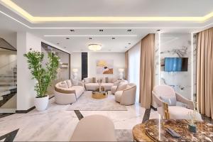 Luxury Stays in Cairo Festival City في القاهرة: غرفة معيشة بأثاث أبيض وتلفزيون