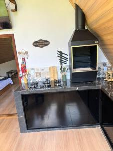 a kitchen with a counter with a stove at Chalé Alpes da Nascente in Salesópolis
