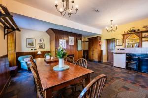 a kitchen and dining room with a wooden table and chairs at Tullymurry House in Ardarragh
