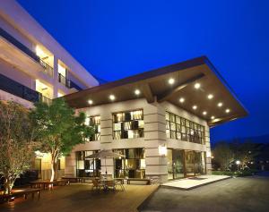 a large white building with a patio at night at The Deer Resort in Yuchi