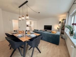 a dining room and living room with a table and a couch at Allgäu Retreat in Bad Wörishofen