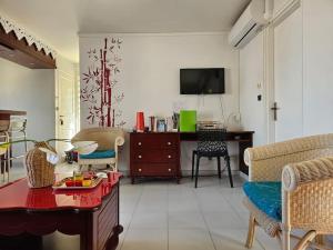 a living room with a table and a tv at T2 cosy piscine - proche plages et bourg in Sainte-Anne