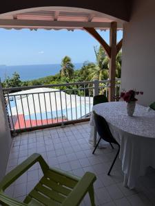 a table and chairs on a balcony with a view of the ocean at Le Joyeux 
