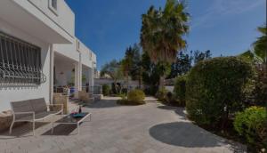 een patio met een bank en bomen en een gebouw bij Elements Rooms in Porto Cesareo