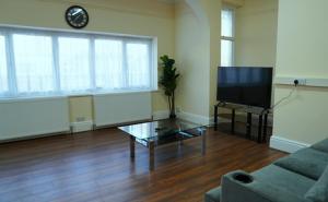 a living room with a couch and a tv at SS Sunrise & Silk in Bersted