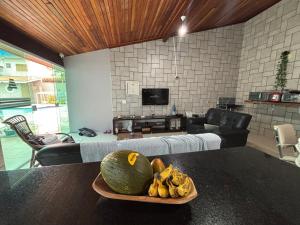 a bowl of fruit on a table in a living room at Moreno Guest House com Piscina, churrasqueira Praia de Itaguaré e Riviera in Bertioga