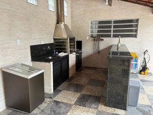 a large kitchen with a stove and a sink at Moreno Guest House com Piscina, churrasqueira Praia de Itaguaré e Riviera in Bertioga