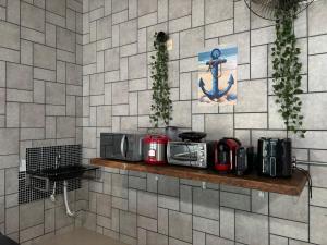a kitchen with a counter with appliances on a wall at Moreno Guest House com Piscina, churrasqueira Praia de Itaguaré e Riviera in Bertioga