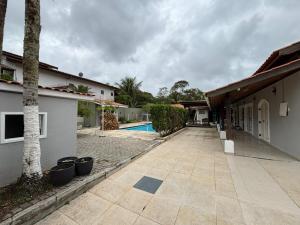 a courtyard of a house with a swimming pool at Moreno Guest House com Piscina, churrasqueira Praia de Itaguaré e Riviera in Bertioga