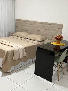 a bedroom with a bed and a table with a table at Golden Point Apartamento em Recife in Recife