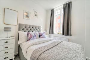 a bedroom with a bed and a dresser and a mirror at New Street - City Centre! in Worcester