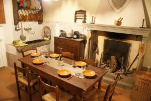 een eetkamer met een tafel en een open haard bij Villa Terria in Casabasciana