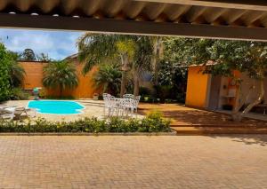 a patio with a table and chairs and a pool at Pousada Vento Sul in Chapada dos Guimarães