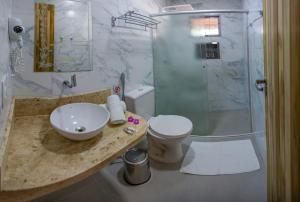 a bathroom with a sink and a toilet and a shower at Pousada Vento Sul in Chapada dos Guimarães +57 photos