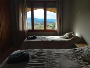 Aires de Horta في هورتا دي سان خوان: غرفة نوم بها سريرين ونافذة