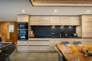 a kitchen with a wooden table and a large kitchen at Le Refuge de Lucien - OVO Network in Gérardmer