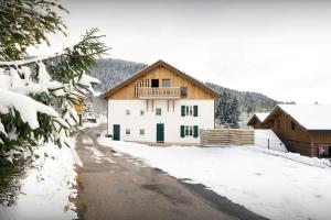 a house with a balcony on a snow covered road at Le Refuge de Lucien - OVO Network in Gérardmer