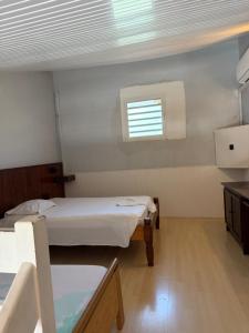 a small room with two beds and a window at Le Joyeux 