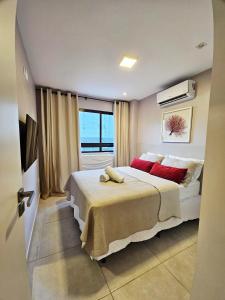 Flat charmoso no Centro de Porto de Galinhas في بورتو دي غالينهاس: غرفة نوم بسرير كبير مع وسائد حمراء