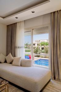 Luxury Stays in Cairo Festival City في القاهرة: غرفة معيشة مع أريكة ونافذة كبيرة