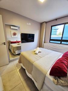 Flat charmoso no Centro de Porto de Galinhas في بورتو دي غالينهاس: غرفة نوم بها سرير كبير وتلفزيون +40 صورة