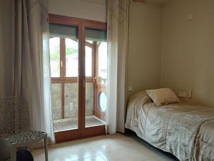 Aires de Horta في هورتا دي سان خوان: غرفة نوم بها سرير ونافذة كبيرة