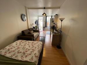 ein Wohnzimmer mit einem Bett und einer Couch in der Unterkunft Le charles in Paris