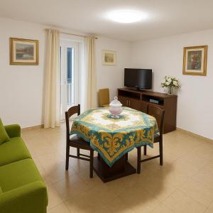 a living room with a table and a tv at Segesta - Le Bouquet in Salemi