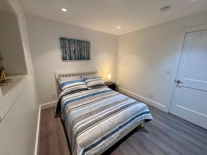 a bedroom with a bed with a striped blanket at A&A Resident in North Vancouver