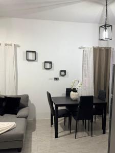 a dining room with a table and a couch at Angella Mansions in Stony Hill +1 photo