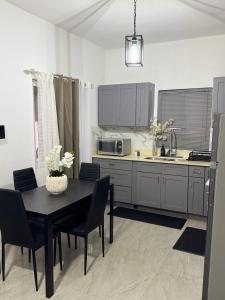 a kitchen with a table and chairs and a microwave at Angella Mansions in Stony Hill
