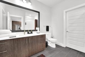 Luxury 2-Bedroom Apartment Near The Battery Atlanta with Pool, Sky Lounge & Free Parking في أتلانتا: حمام مع حوض ومرحاض ومرآة +10 صور