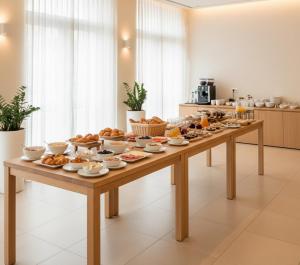 un lungo tavolo di legno con sopra un mucchio di cibo di Veranda Hotel Ölüdeniz a Fethiye