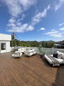 un patio con sofás y sillas en una terraza de madera en Spacious Group Villa with Jacuzzi and Views, en Askøy