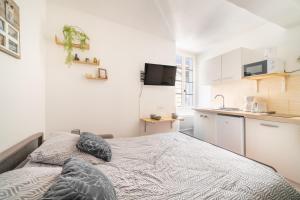 a small bedroom with a bed and a kitchen at Studio cosy et lumineux Centre de Beaucaire - cocon 3 in Beaucaire
