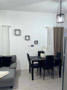 a dining room with a black table and chairs at Angella Mansions in Stony Hill