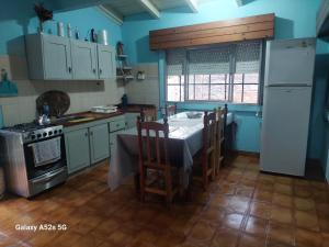 a kitchen with a table and a white refrigerator at El RINCÓN in Oberá +28 photos