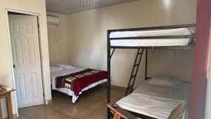 two bunk beds in a room with a door at Cabañas Green Hills in Las Minas