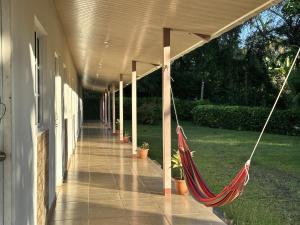 a porch with a hammock on the side of a building at Cabañas Green Hills in Las Minas