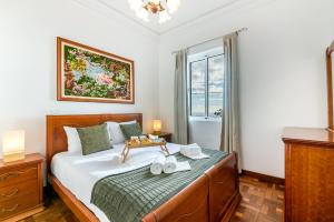 a bedroom with a large bed and a window at Casa da Georgina by GALMI in Arco da Calheta