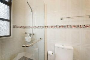 a bathroom with a white toilet and a shower at Casa da Georgina by GALMI in Arco da Calheta +28 photos