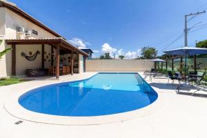 een groot blauw zwembad naast een huis bij Refúgio Casa Pitinga in Porto Seguro +13 foto's