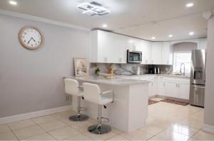 een keuken met witte kasten en een klok aan de muur bij Home Luxury in Tampa +7 foto's