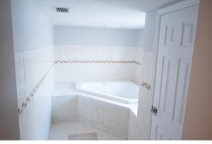 een witte badkamer met een bad in de kamer bij Home Luxury in Tampa